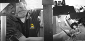 Worker checking manufacturing equipment up close.