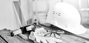 Personal protective equipment including a helmet and safety glasses on a table.