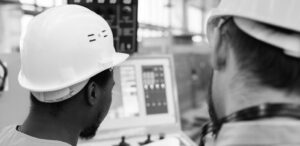 Workers evaluating a checklist of safety tips for hot melt system maintenance.